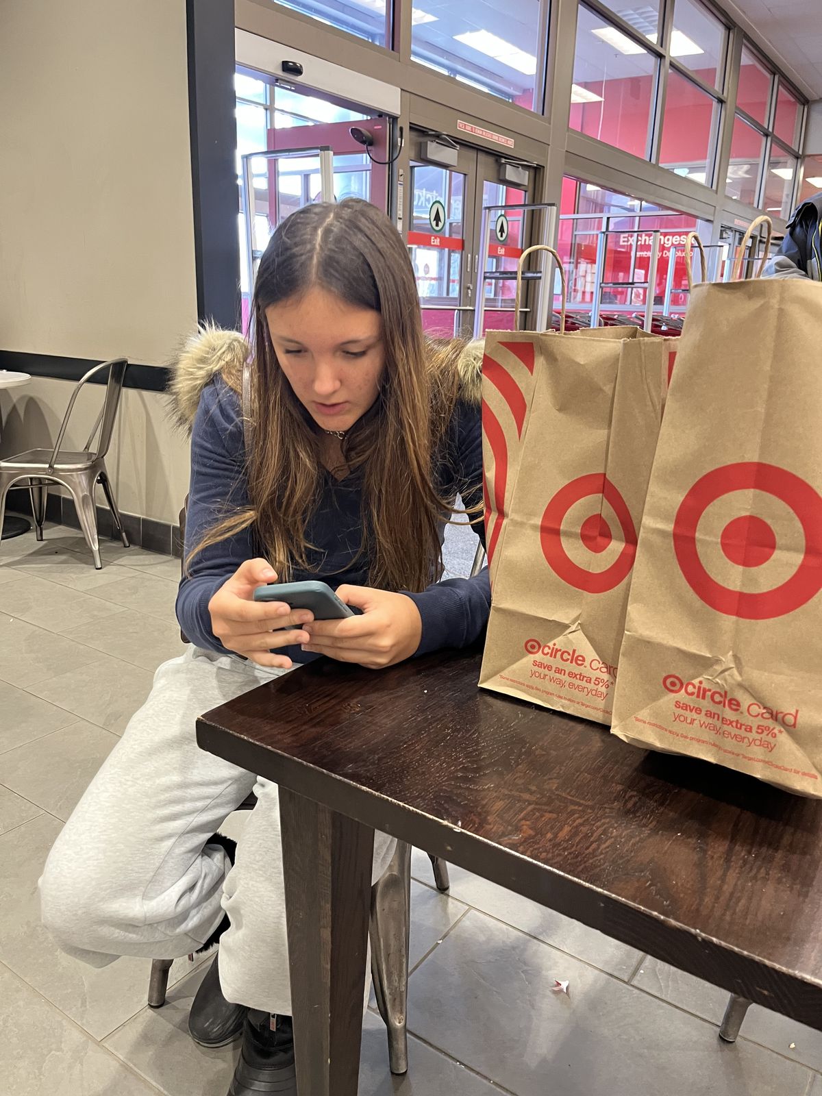 Ruby at a table with Target shopping bags